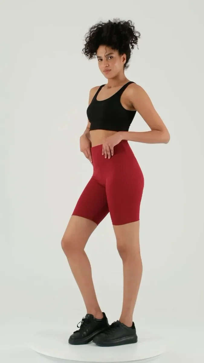 Vücudu şekillendiren kısa taytlar da uzun modeller kadar etkilidir. Bu kırmızı yüksek bel model, karın ve kalça bölgesinde toparlayıcı etki sunarak spor kombinlerine cesur bir alternatif oluşturur.

